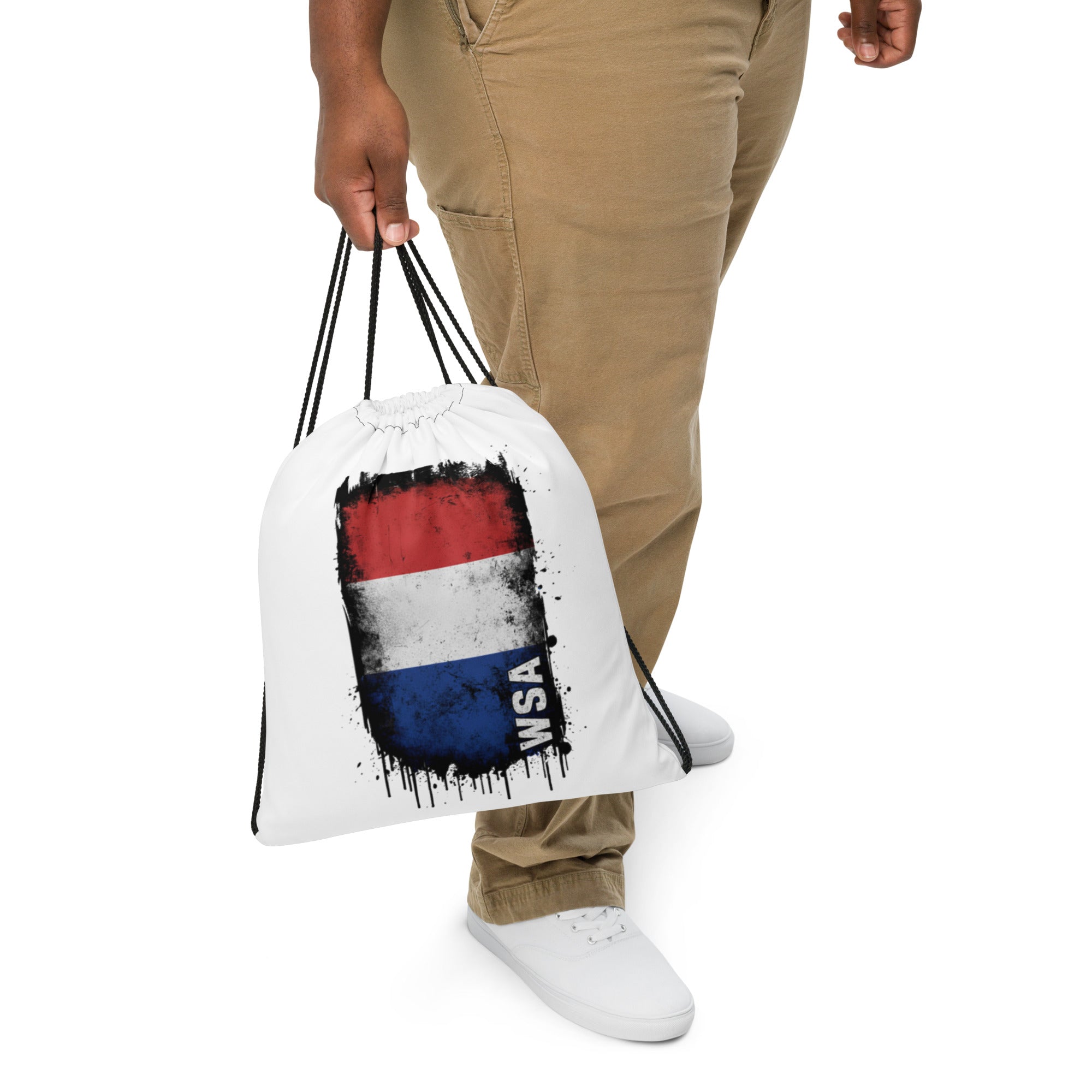 Person holding a drawstring bag with a flag design and 'WSA' text on a white background