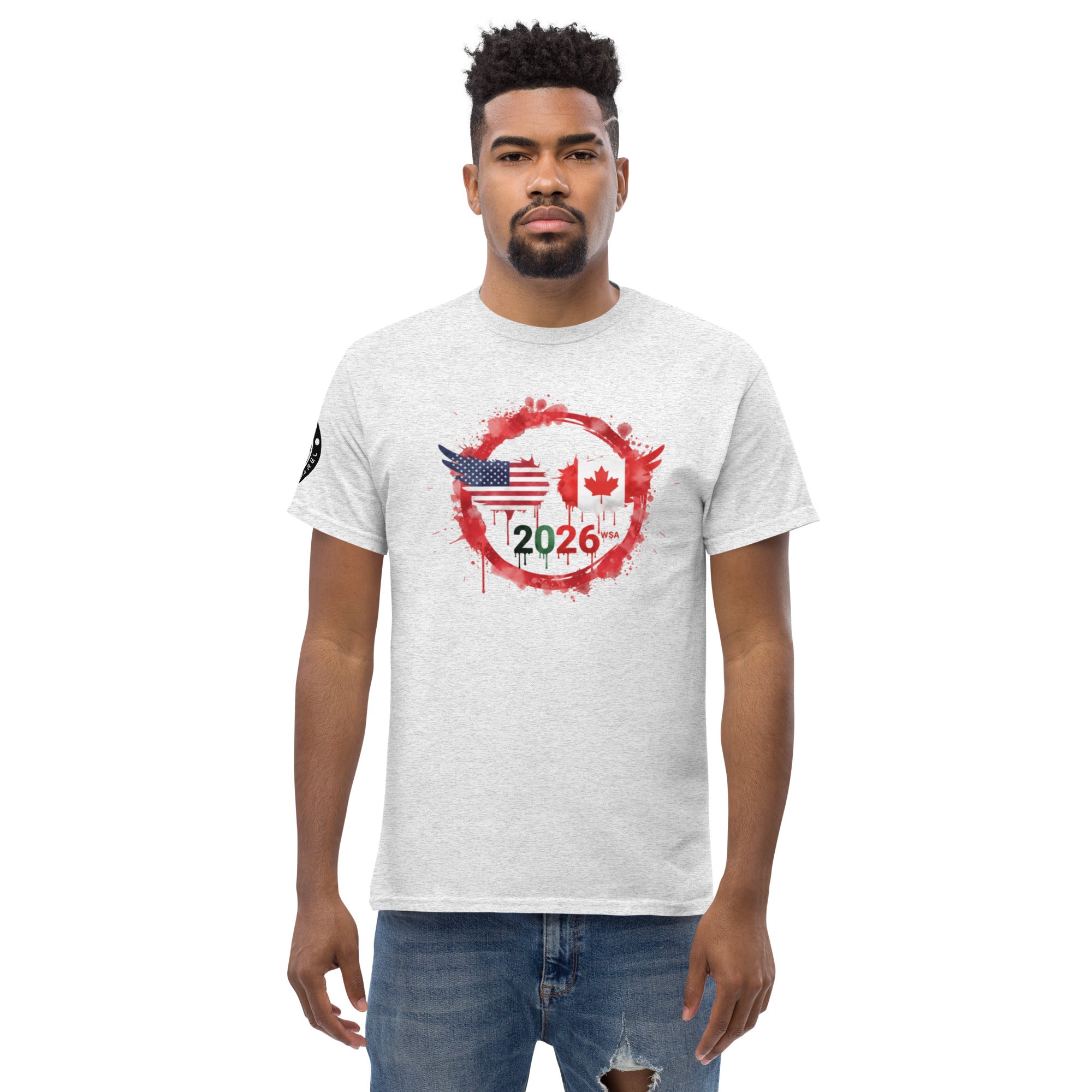 Man wearing a white t-shirt with a graphic design featuring the American and Canadian flags and the year 2026 on a white background.
