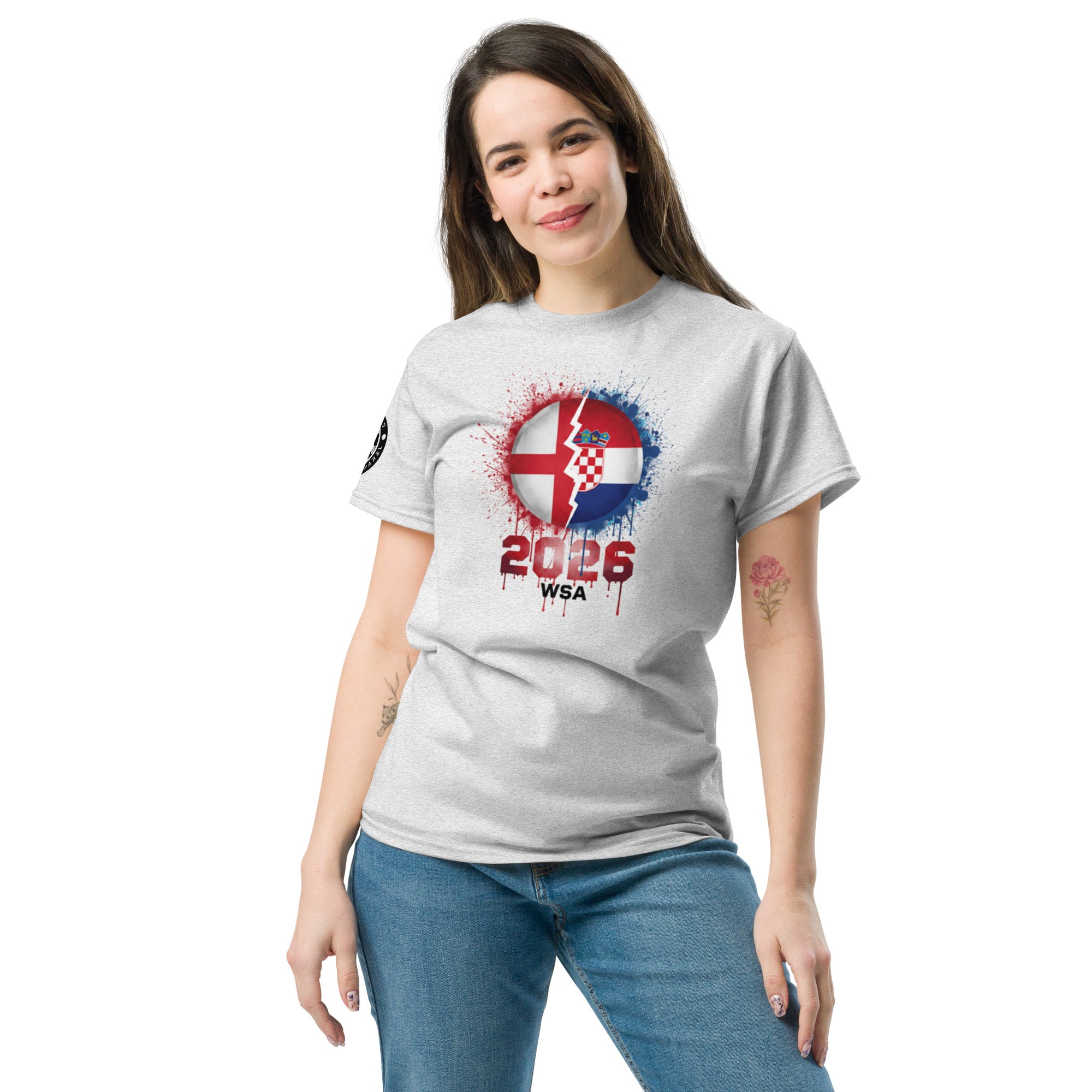 Woman wearing a gray t-shirt with a design featuring the number 2026 and text on a white background