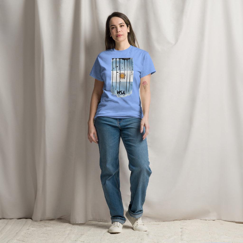 Person wearing a blue t-shirt with a graphic design and text, standing against a plain background