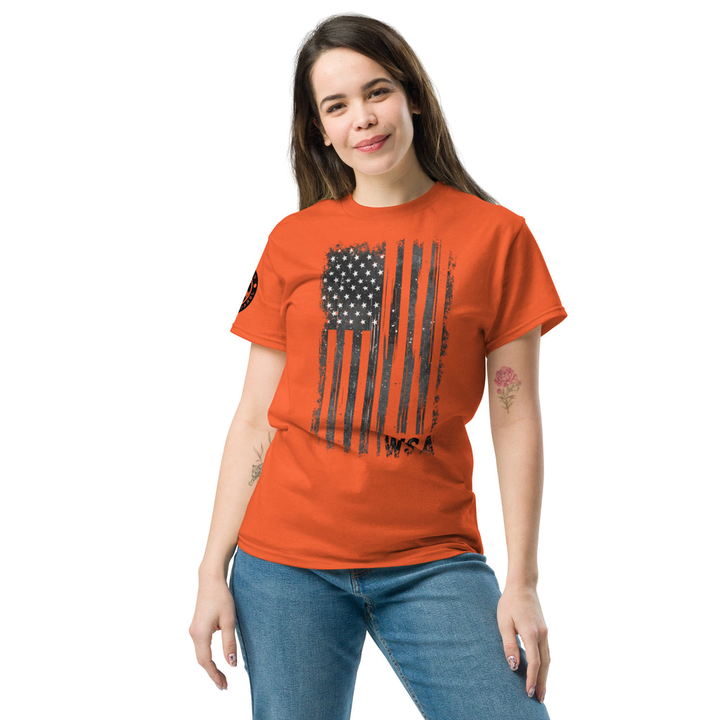 Woman wearing an orange t-shirt with a black and white flag design on a white background