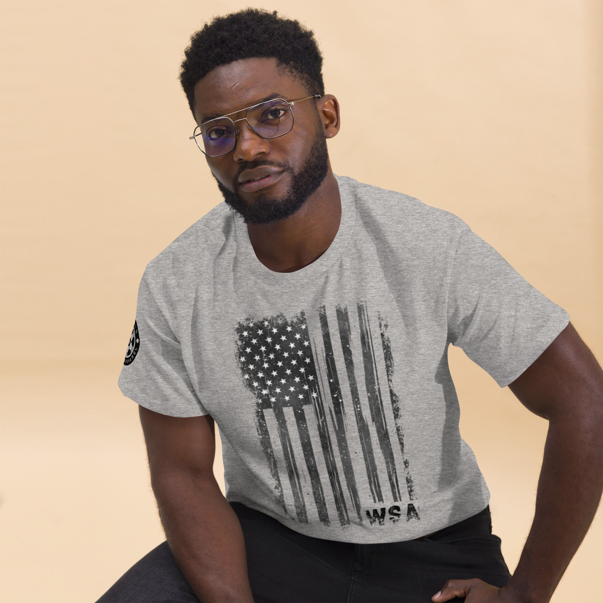 Man wearing a gray t-shirt with an American flag design on a beige background