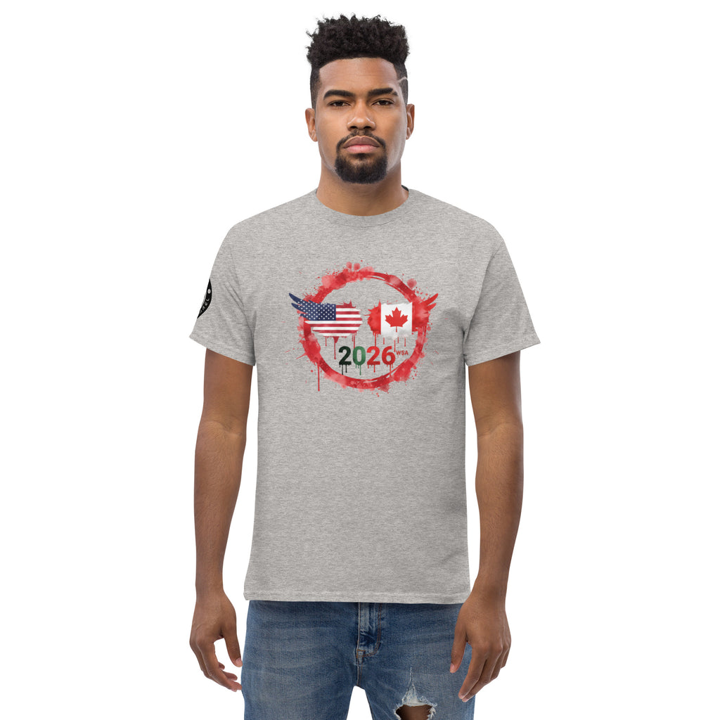 Man wearing a gray t-shirt with a graphic design featuring an American flag, Canadian flag, and the year 2026 on a white background.