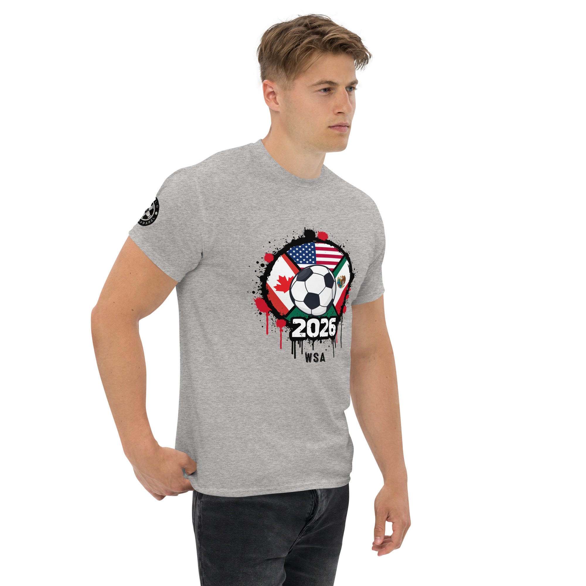 Man wearing a gray t-shirt with a graphic design featuring a soccer ball, American flag, and '2026' text.