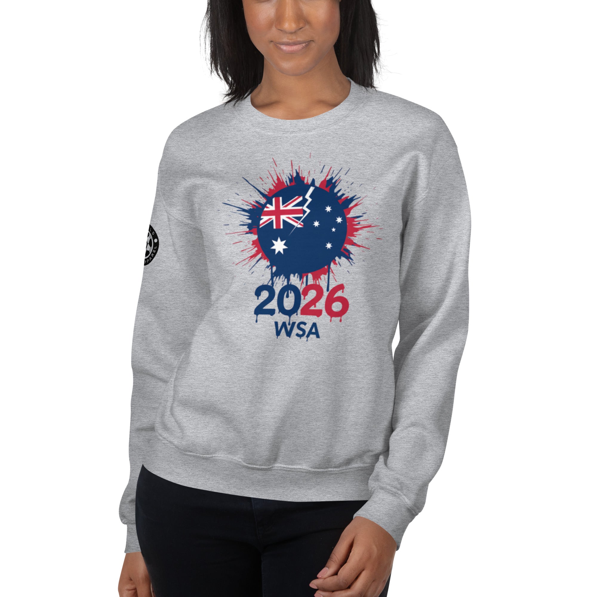 Person wearing a gray sweatshirt with a design featuring the number 2026 and text on a white background