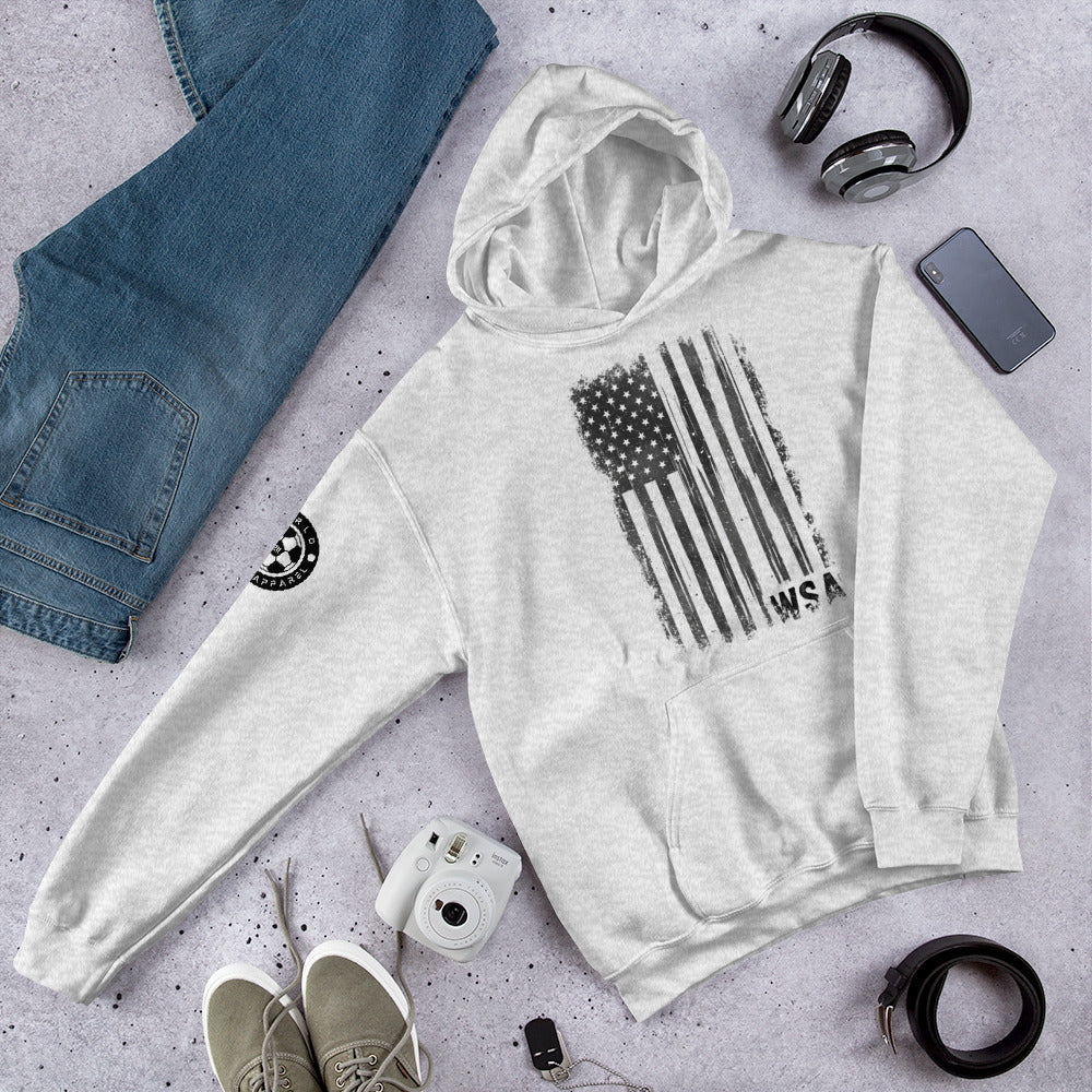 White hoodie with American flag design on a gray surface with jeans, shoes, and accessories.