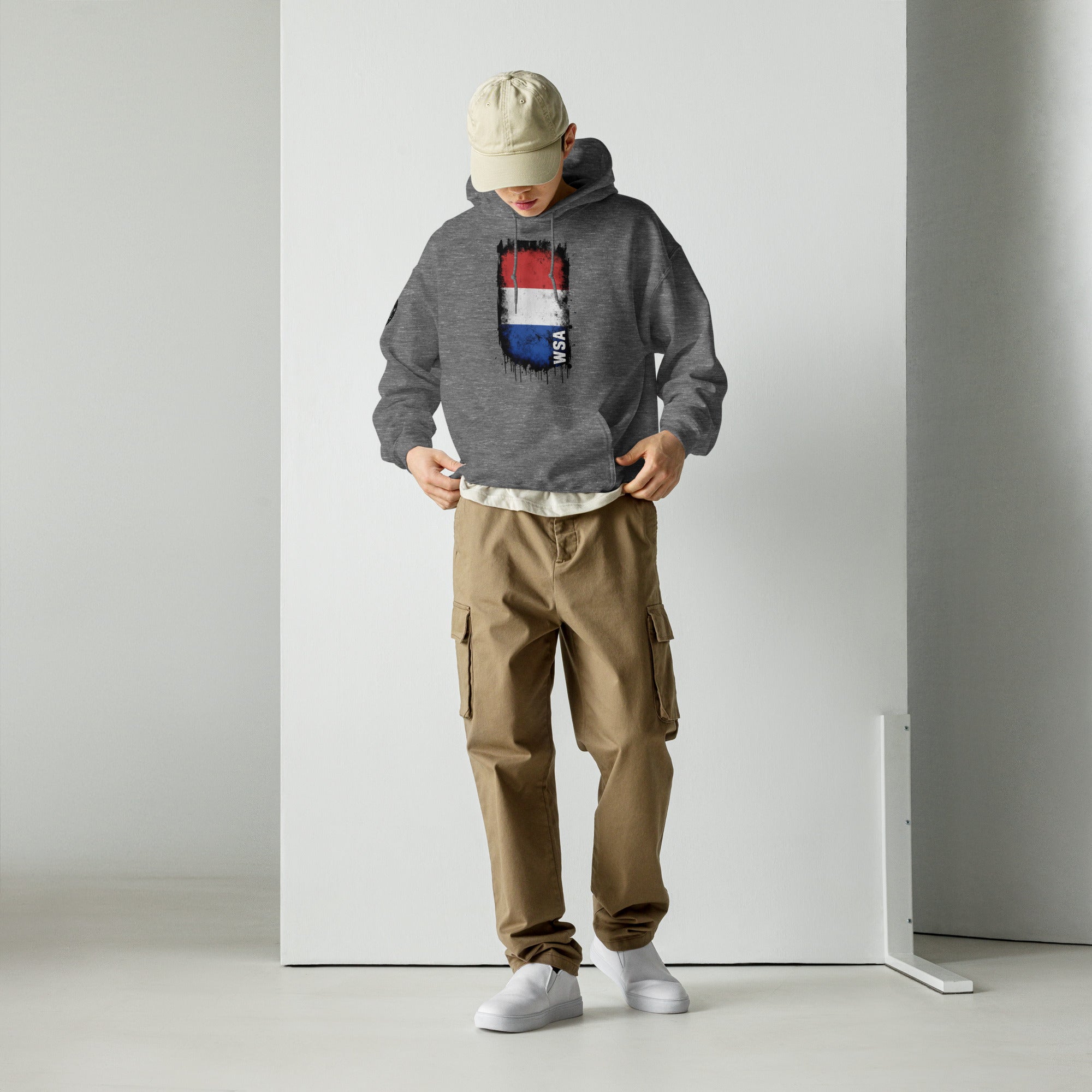 Person wearing a gray hoodie with a colorful logo and brown cargo pants against a white background