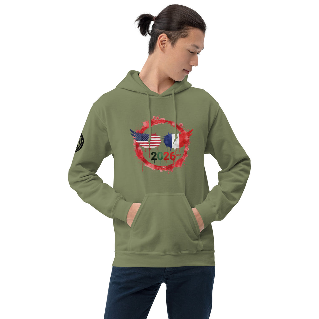 Person wearing a green hoodie with a design of an American and French flag, along with the number 2026, on a white background.