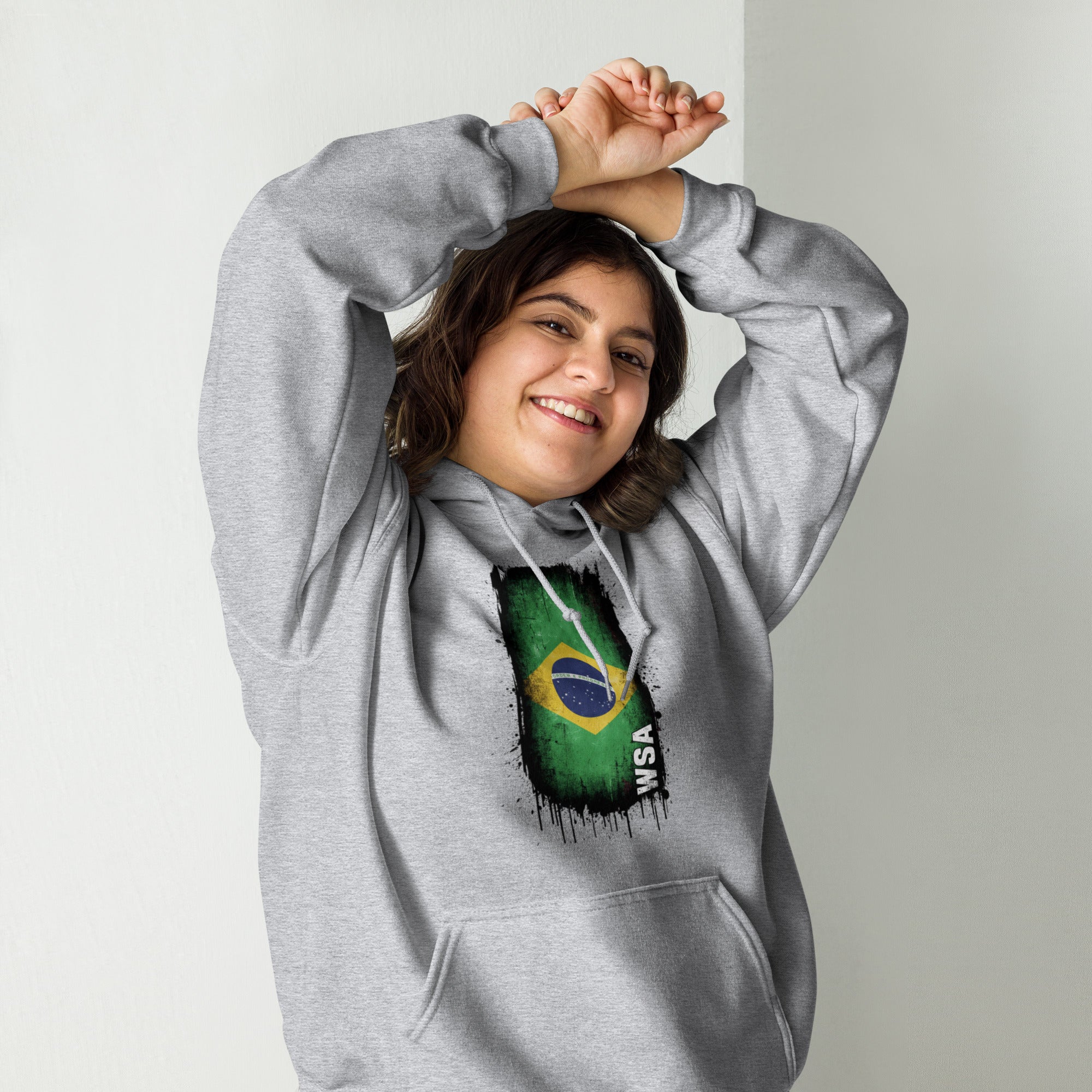Person wearing a gray hoodie with a Brazilian flag design on a plain background