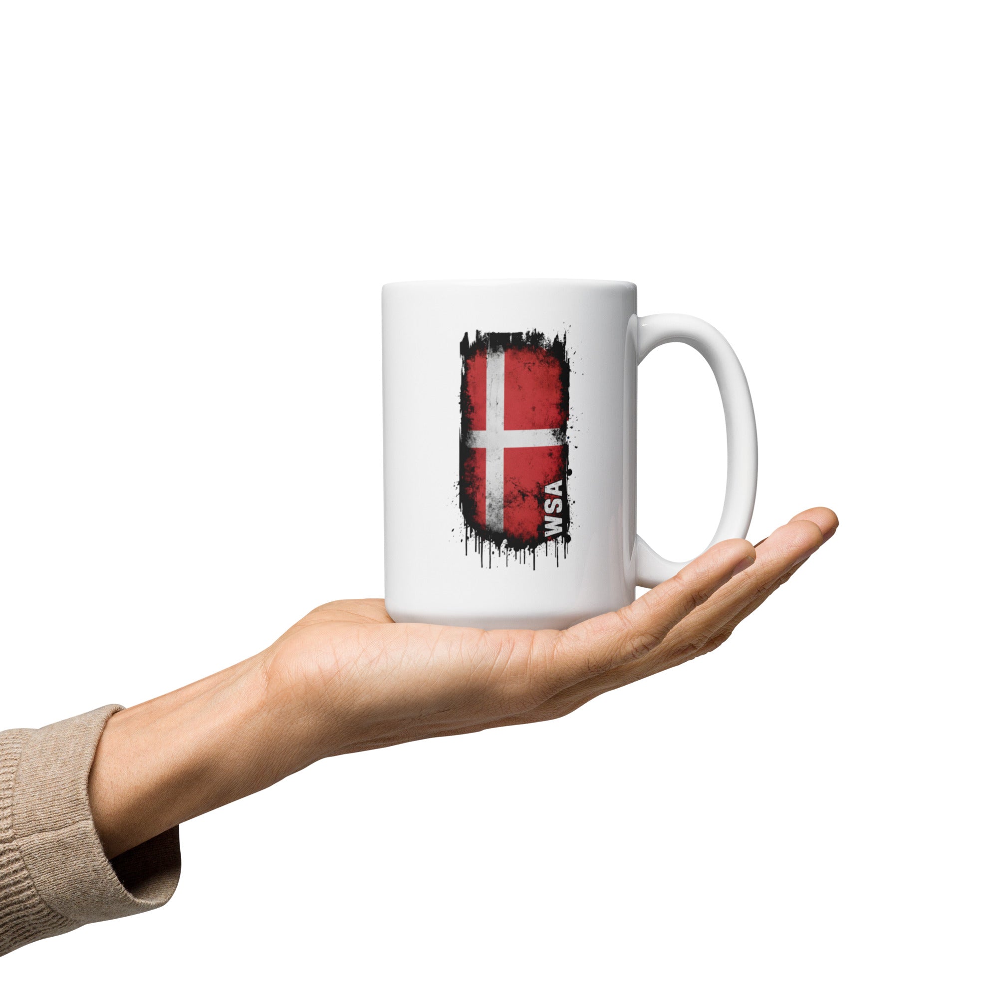 Hand holding a white mug with a flag design on a white background