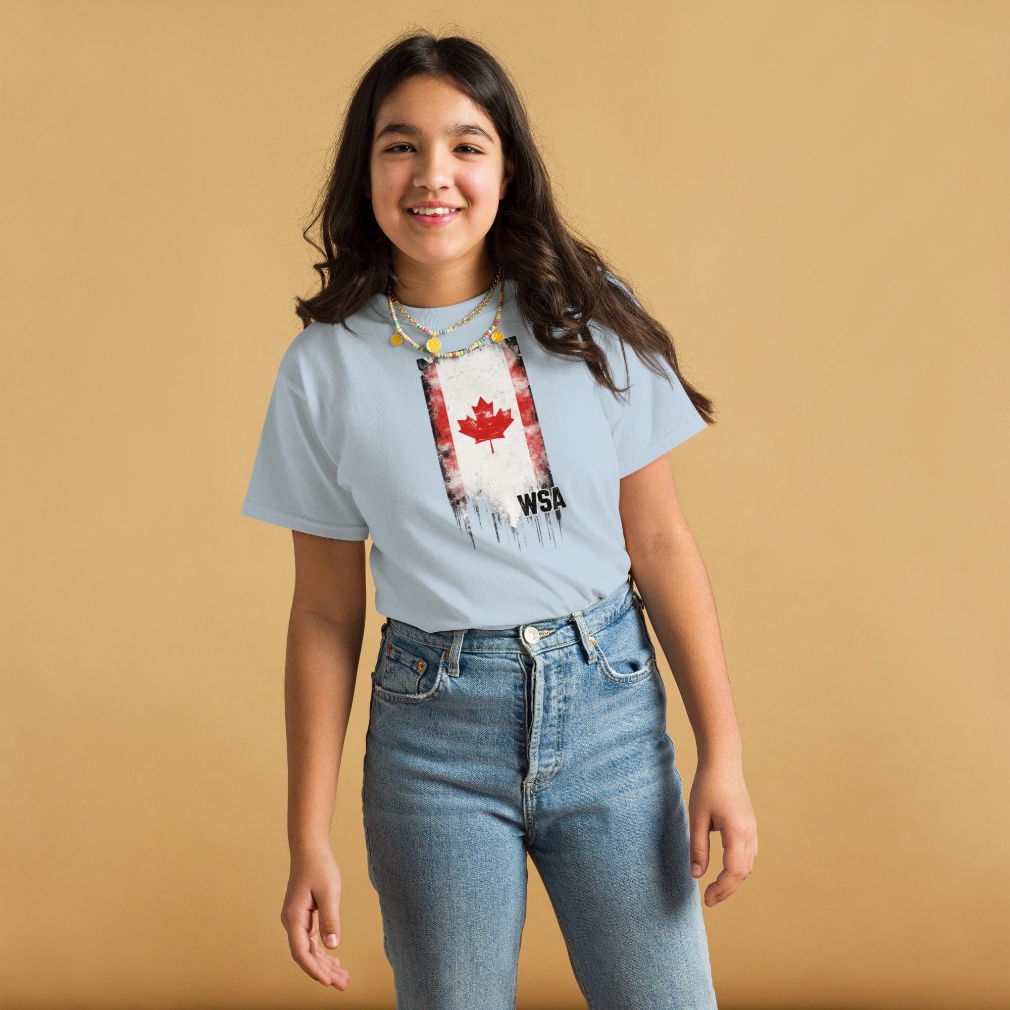 Person wearing a light blue t-shirt with a graphic design on a beige background