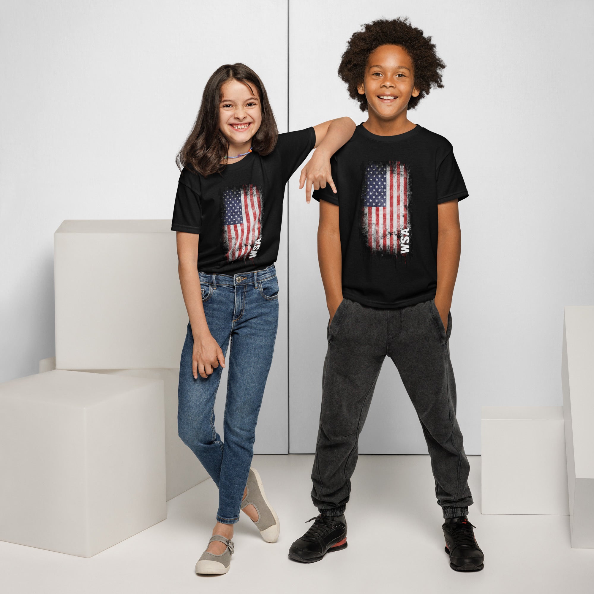 Two children wearing black t-shirts with American flag designs on a white background.
