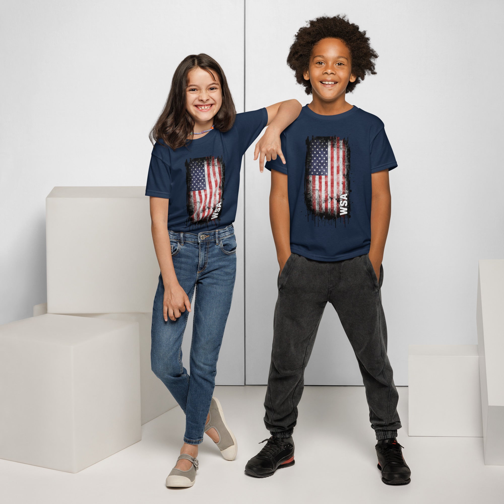 Two children wearing navy blue t-shirts with an American flag design, standing against a white background.